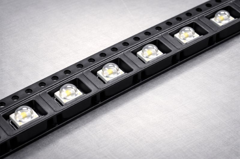 Top-down view of LED components seated in embossed carrier tape pockets with D1 holes